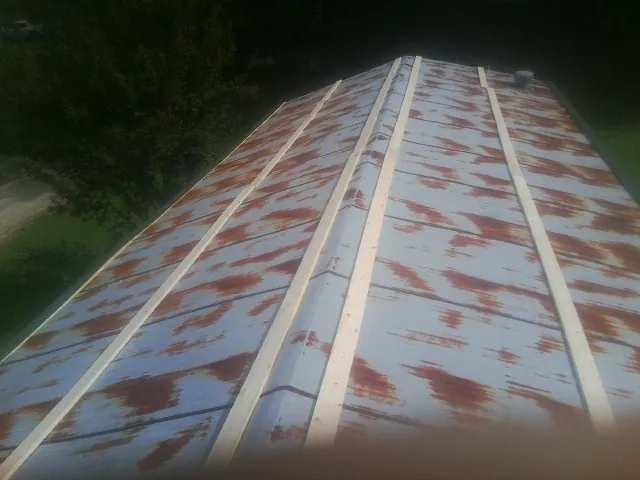 Rusted metal roof panels with new wood purlins before replacement — Storm Damage Roof Repair in Huron by Roofing Brothers